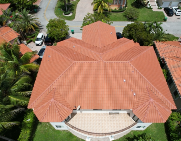 Top-down aerial view of a residential building featuring a terracotta clay tile hip roof with multiple gables.